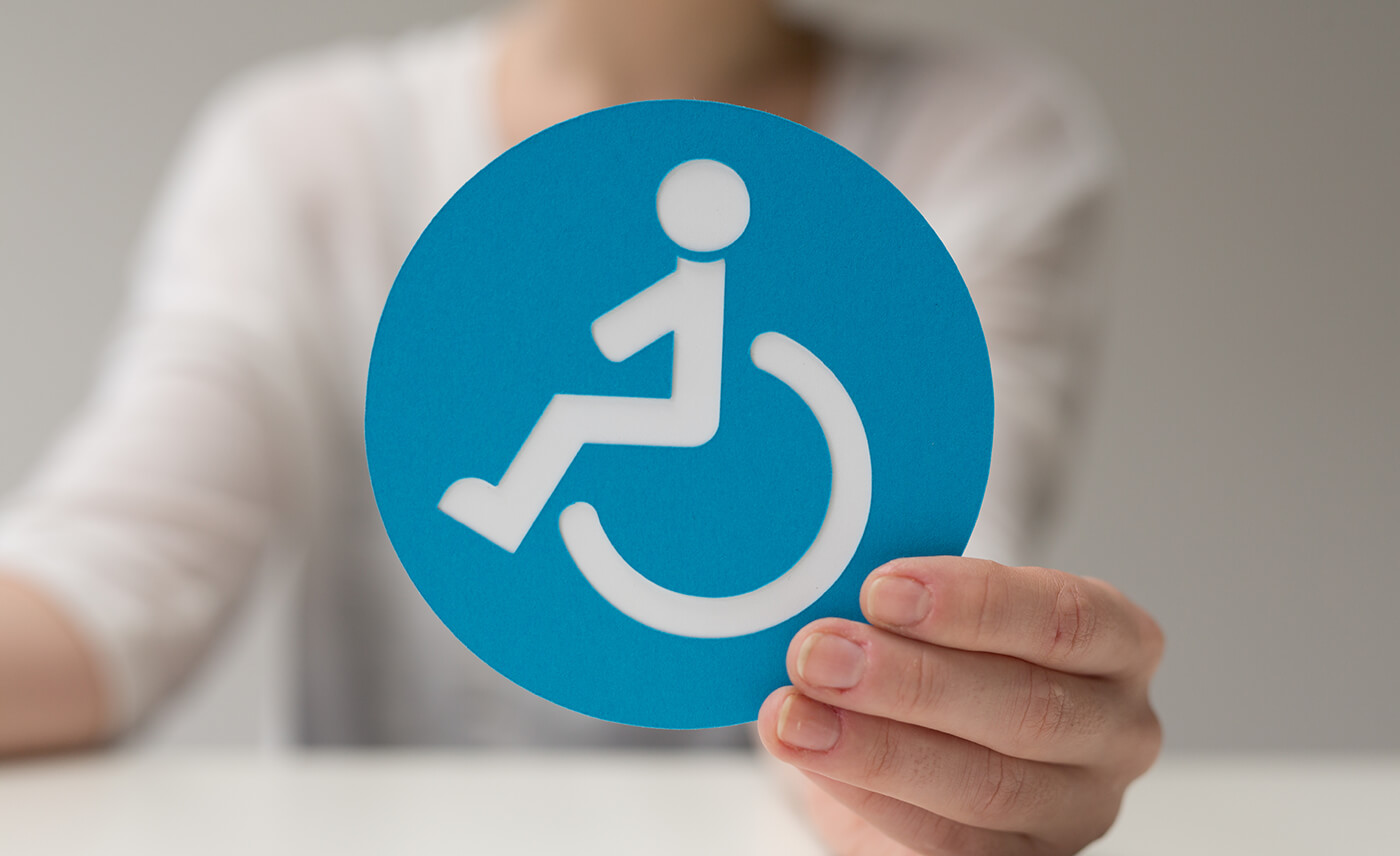 Person holding a blue handicapped sign.